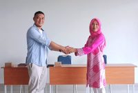 Ketua Komite SMPN 22 Kota Bogor terpilih Billy Adhiyaksa berjabat tangan dengan Kepala Sekolah Panggih Nawangsih Hartanti usai pemilihan pengurus, Jumat (29/8/2025).